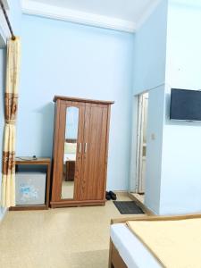 een kamer met een houten kast en een spiegel bij Nhà Nghỉ Duy Tân in Sầm Sơn