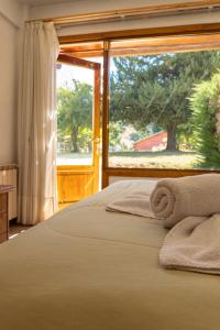 1 dormitorio con cama y ventana grande en Loft Catedral by Base 41 en San Carlos de Bariloche