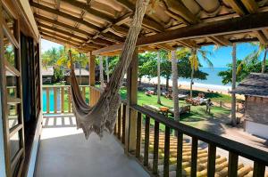 a porch with a hammock and a view of the beach at Pousada Cores do Mar Caraíva in Caraíva