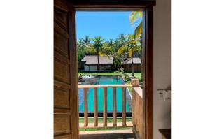 a view of a swimming pool from a door at Pousada Cores do Mar Caraíva in Caraíva
