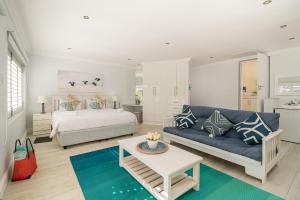 uma sala de estar com uma cama e um sofá azul em One on Bollard em Knysna