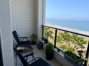 a balcony with a table and chairs and the beach at Дом на пляже in Batumi +2 photos