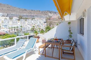 d'un balcon avec des chaises et une table offrant une vue sur la ville. dans l'établissement Cliff View Terrace by Dream Homes Tenerife, à Puerto de Santiago