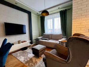 a living room with a couch and a flat screen tv at Apartament Ezuka - Twoje miejsce na mazurach in Giżycko