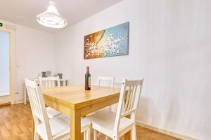 comedor con mesa de madera y sillas blancas en Apartamento La Capilla by Clabao, en Pamplona