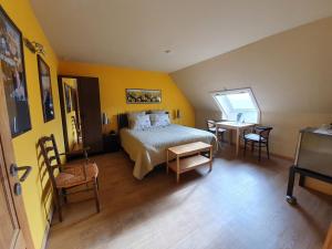 a bedroom with a bed and a table and chairs at B&B Herberg Boerenhol in Poperinge +26 photos