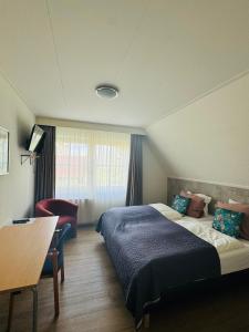 Habitación de hotel con cama grande y escritorio. en Bed&Breakfast hotel de Greune Weide en Eibergen