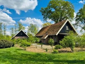 una casa antigua con techo en un césped verde en Bed&Breakfast hotel de Greune Weide en Eibergen