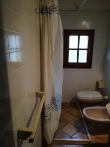 baño con ducha y aseo y ventana en Marinho, en Cavo