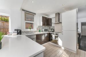 a kitchen with white appliances and a white counter top at London Apartment Near The London Eye in London