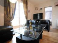 a living room with a black couch and a glass table at Appartement De Charme in Amboise