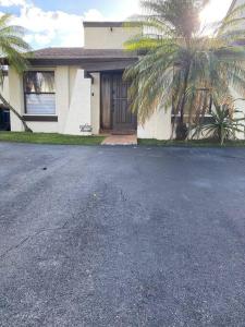 a house with a palm tree in front of a driveway at Cozy 2 Bedroom Modern Farmhouse in Miami in Tamiami