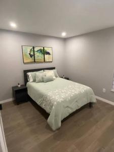 a bedroom with a large bed with two paintings on the wall at Cozy 2 Bedroom Modern Farmhouse in Miami in Tamiami