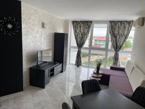 un soggiorno con un divano viola e una TV di Apartment with Pool in Atlantis Resort a Burgas