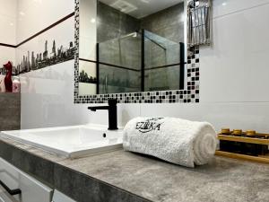 a bathroom with a sink with a towel on a counter at Apartament Ezuka - Twoje miejsce na mazurach in Giżycko