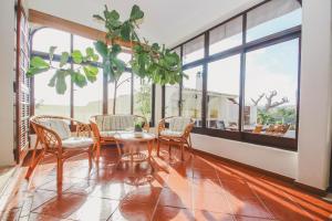 Villa Honolulu by Algarve Vacation في ألبوفيرا: غرفة طعام مع طاولة وكراسي ونوافذ