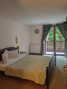 une chambre avec un grand lit et une fenêtre dans l'établissement Casuta Din Padure Malaia, à Malaia