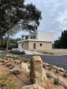 ein Haus mit einem großen Felsen davor in der Unterkunft Chambres d hôtes Maison des Romarins in Montferrier-sur-Lez