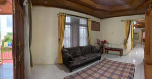 ein Wohnzimmer mit einer Couch und einem Fenster in der Unterkunft Garuda Homestay in Bukittinggi