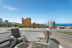 2 stoelen op een balkon met uitzicht op de oceaan bij Las Flores 407 in Playa Fañabe