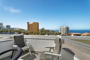 two chairs on a balcony with a view of the ocean at Las Flores 407 in Playa Fañabe