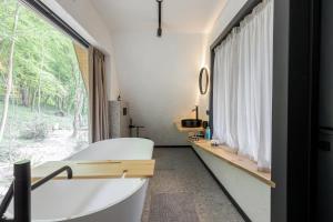 a bathroom with a tub and a large window at Time ForRest in Maidan Village