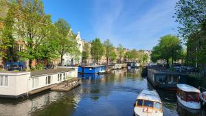 a group of boats docked in a canal with houses at BnB Souterrain in Amsterdam