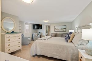 a bedroom with a large bed and a mirror at Sojourn Family home with Country Club Access 5 Bedrooms Sleeps 12 in Kill Devil Hills +21 photos