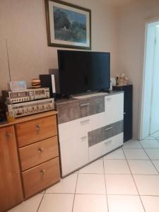 a tv sitting on top of a dresser in a room at Apartment Am Mühlenbusch in Neuss +2 photos