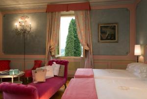 a bedroom with a bed and a couch and a window at Villa la Borghetta Spa Resort in Figline Valdarno