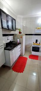 a kitchen with a refrigerator and a red rug at Apto aconchegante cuiaba in Cuiabá