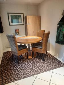 una mesa de comedor con sillas de mimbre en una habitación en Apartment Am Mühlenbusch en Neuss