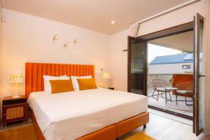 sypialnia z dużym łóżkiem i balkonem w obiekcie Quinta de Cabanas Douro - By Unlock Hotels w mieście Penha Longa