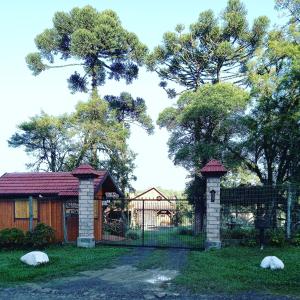 ein Tor vor einem Haus mit Bäumen in der Unterkunft Sítio Cabanas da Lu in Canela