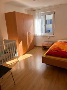 - une chambre avec un lit, une armoire et une fenêtre dans l'établissement La Preferita, à Magadino