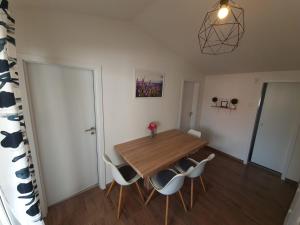 a dining room with a wooden table and chairs at Apartment Vi & La ELECTRIC SCOOTERS included in Vir +15 photos
