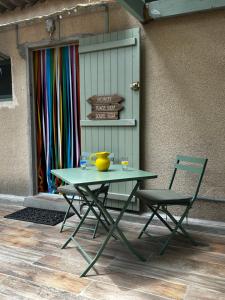 einem grünen Tisch und einem Stuhl neben einer Wand in der Unterkunft Cabanon à Sanary sur mer au coeur de Portissol. in Sanary-sur-Mer