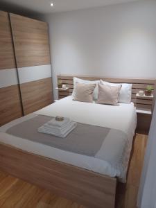 a bedroom with a bed with a wooden headboard at Natura House in Aveiro