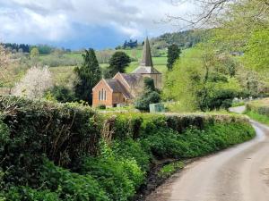 a dirt road leading to a church with a church steeple at 1 bed in Coreley CHL32 in Coreley