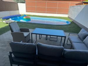 a patio with a table and chairs next to a pool at Belle Casa Villa in Debrecen