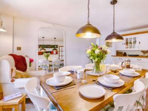een eetkamer met een houten tafel en witte stoelen bij 3 Bed in Weymouth 88169 in Weymouth
