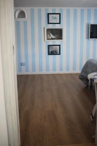 Pokój z niebiesko-białymi paskami i drewnianą podłogą w obiekcie la mansarda sul mare w mieście Ponza
