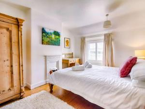 1 dormitorio con 1 cama blanca grande y chimenea en 3 Bed in Weymouth 88169 en Weymouth
