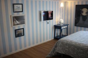 1 dormitorio con 1 cama y TV en la pared en la mansarda sul mare en Ponza