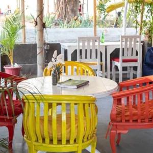 una mesa con 4 sillas y una mesa con un libro en Bintang Tiga Bungalows Gili Air, en Gili Air