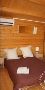- une chambre avec un lit et un mur en bois dans l'établissement Villa de charme à Martignargues avec piscine privée, à Martignargues 9 autres photos