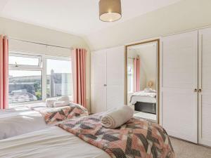 1 dormitorio con 2 camas y ventana grande en 3 Bed in Bude 89425, en Bude