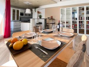een keuken en eetkamer met een tafel met borden en glazen bij Noisy-le-roi Cœur-Village in Noisy-le-Roi