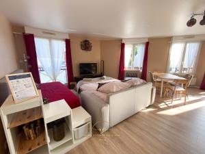 een slaapkamer met een bed en een tafel en ramen bij Noisy-le-roi Cœur-Village in Noisy-le-Roi