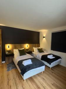 シャモニー・モンブランにあるApartment Mont Blancのベッド2台、薄型テレビが備わるホテルルームです。
